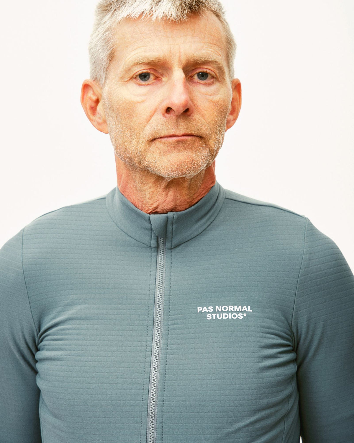 Maillot Largo Pas Normal Studios Essential en Grey Teal, detalle sobre ciclista #Color_Grey Teal