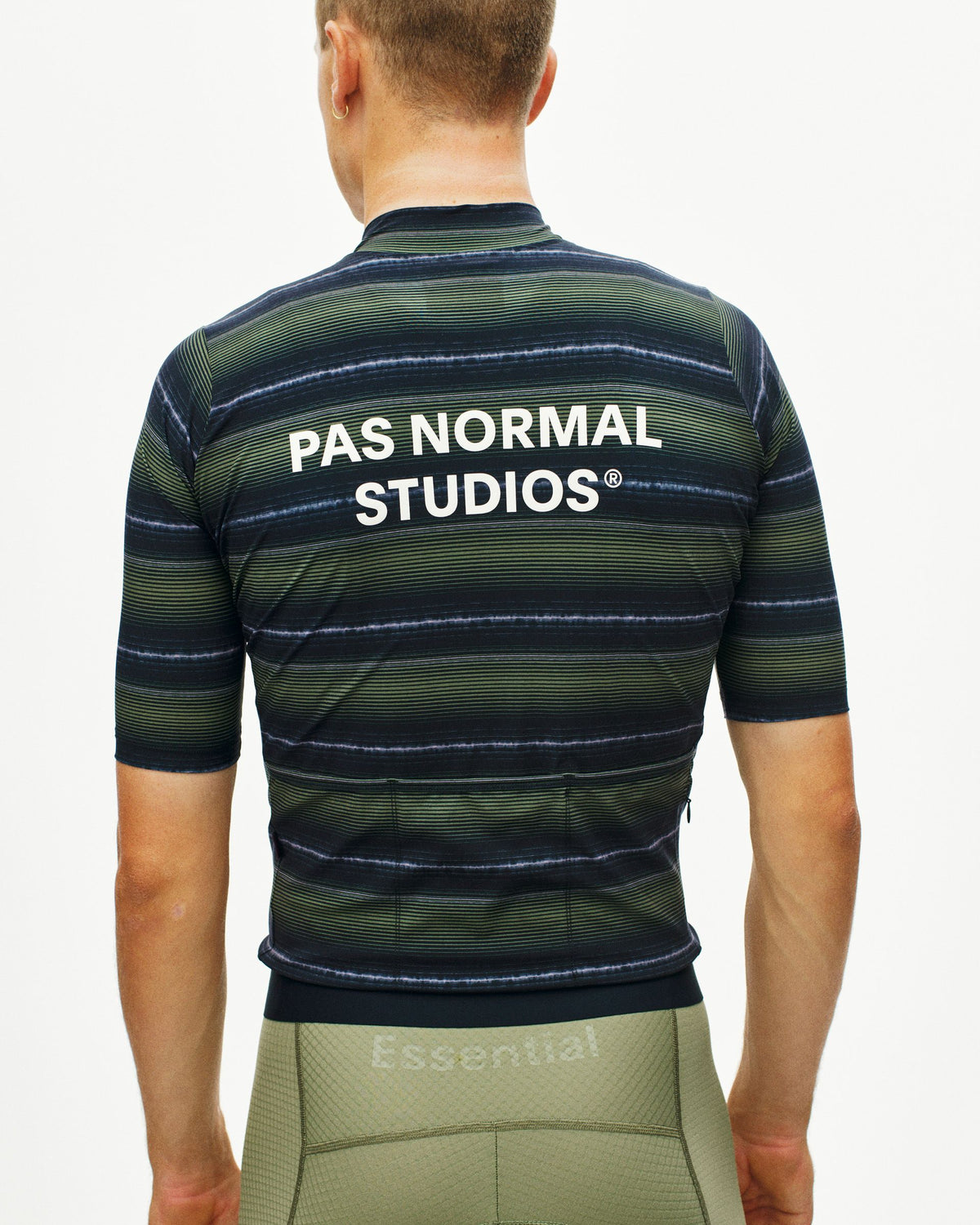 Maillot Corto Pas Normal Studios Essential en Light Olive Stripe, detalle sobre ciclista #Color_Light Olive Stripe