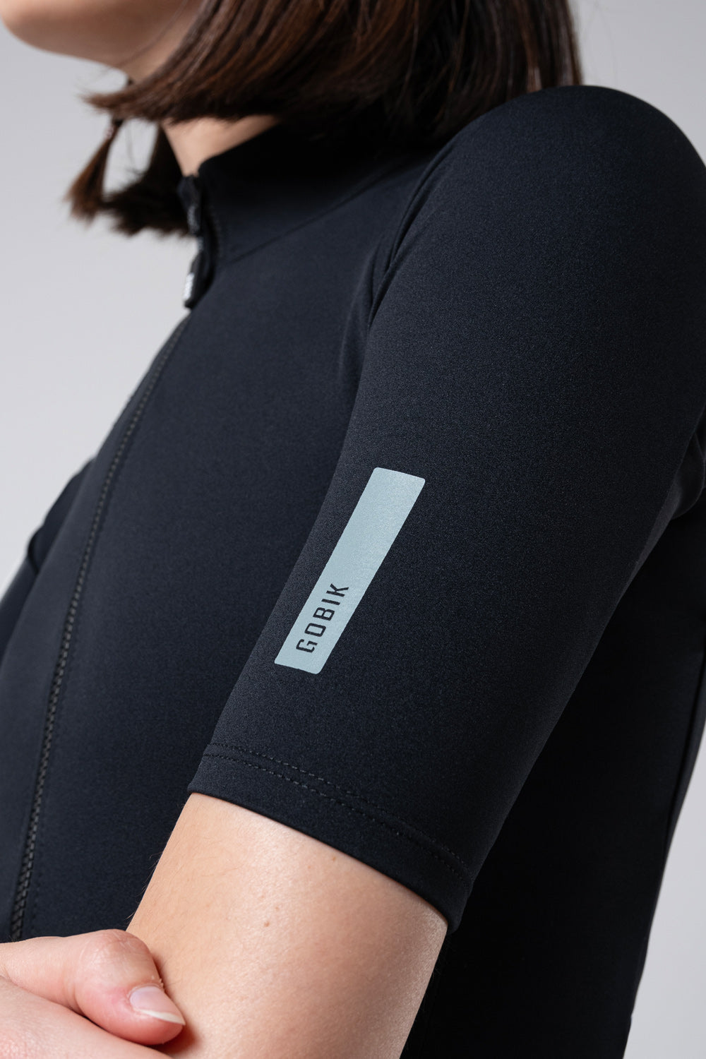 Chaqueta Manga Corta Mujer Gobik Envy 2.0 en Jet Black, detalle del puño de la manga corta con el logotipo #Color_Jet Black