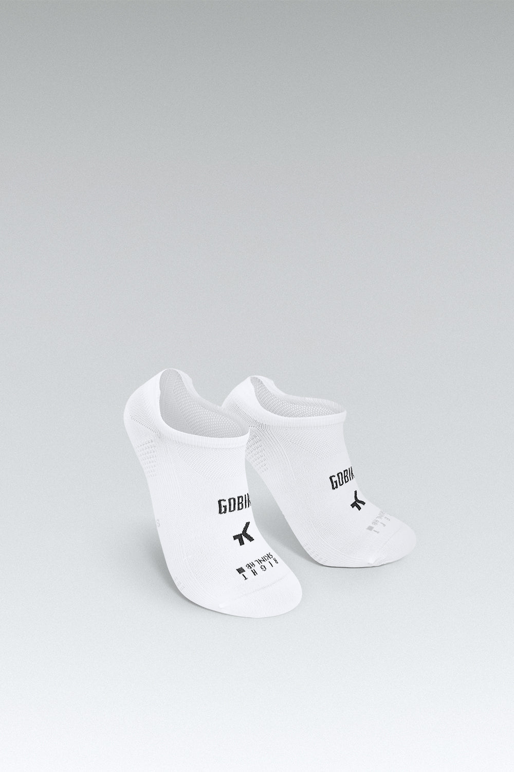 Calcetines Gobik Pinkie Tab Lightweight 2.0 en White, bodegón del par de calcetines invisibles blancos sobre fondo gris #Color_White