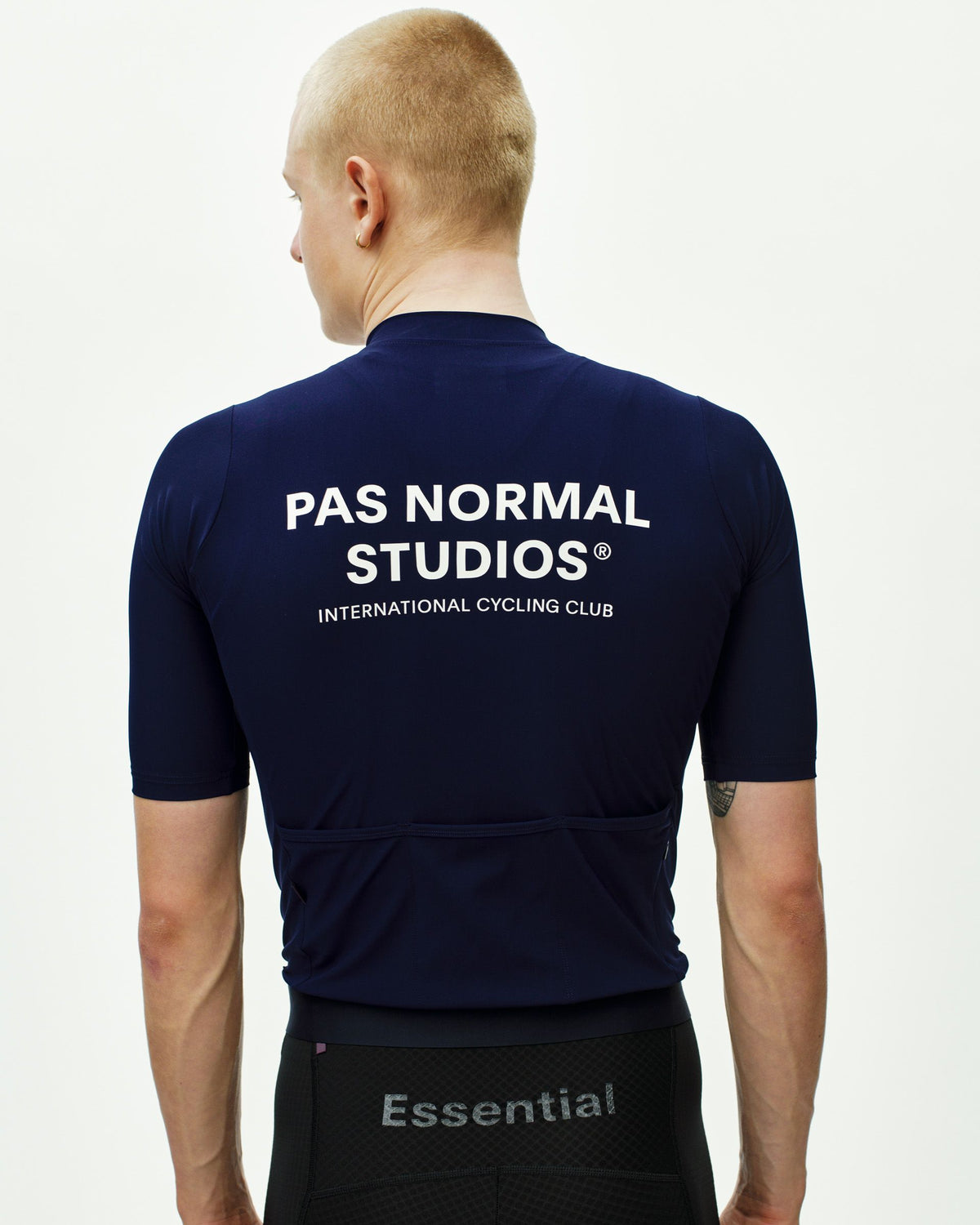 Maillot Corto Pas Normal Studios Essential en Navy, vista trasera sobre ciclista #Color_Navy