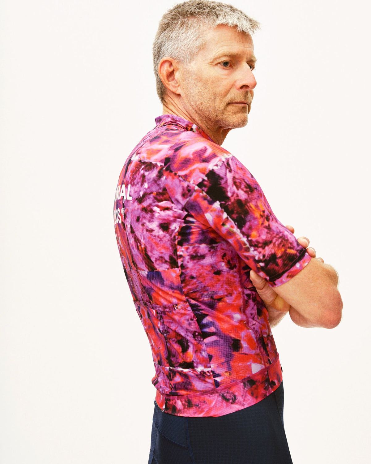 Maillot Corto Pas Normal Studios Essential en Kaleidoscope Pink, vista trasera sobre ciclista #Color_Kaleidoscope Pink