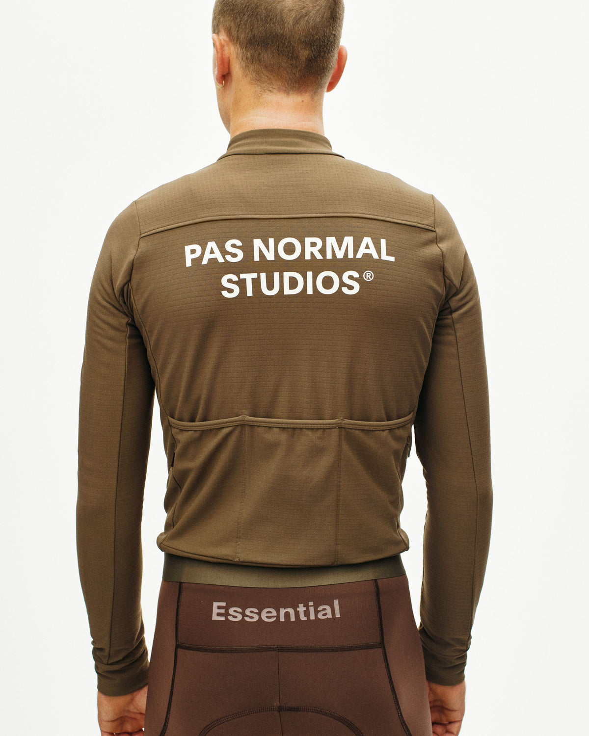 Maillot Largo Pas Normal Studios Essential en Ash Brown, detalle sobre ciclista #Color_Ash Brown