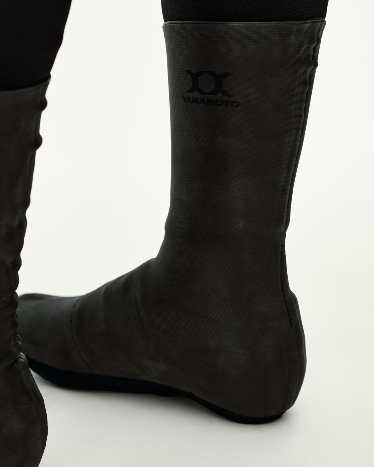 Black Logo Heavy cycling overshoes, side detail on model with Yamamoto chest logo print #Color_Black