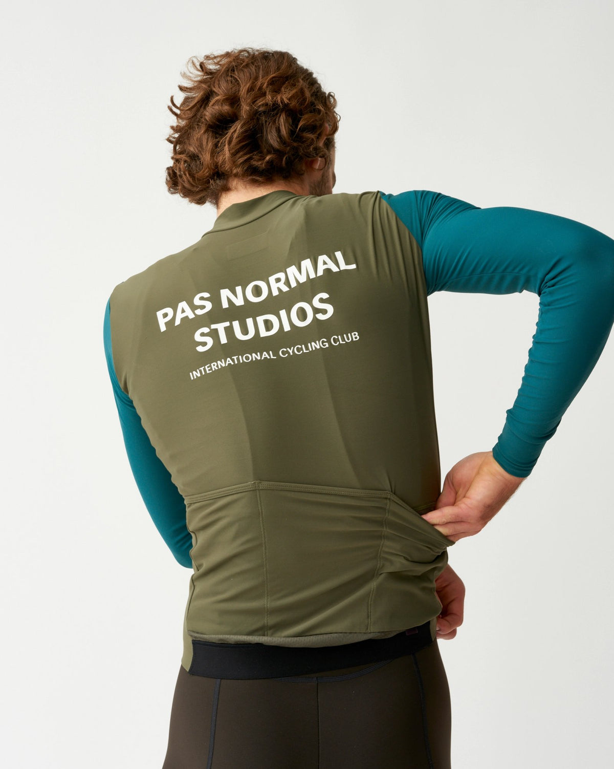Maillot Largo Pas Normal Studios Mechanism en Olive, vista trasera sobre ciclista #Color_Olive