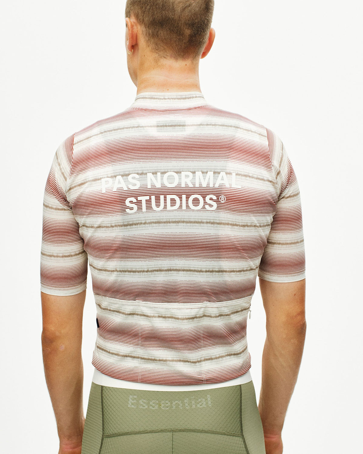 Maillot Corto Pas Normal Studios Essential en Off White Stripe, detalle sobre ciclista #Color_Off White Stripe