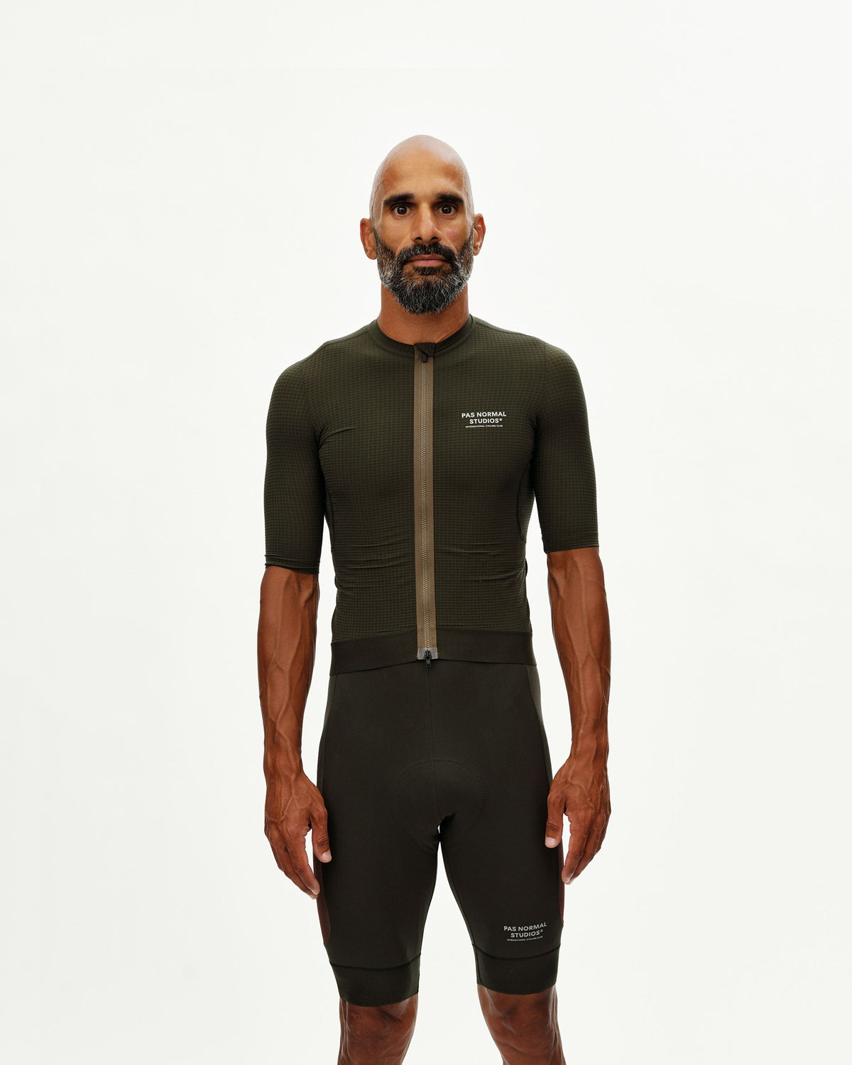 Maillot Corto Pas Normal Studios Escapism en Dark Olive, vista frontal sobre ciclista #Color_Dark Olive