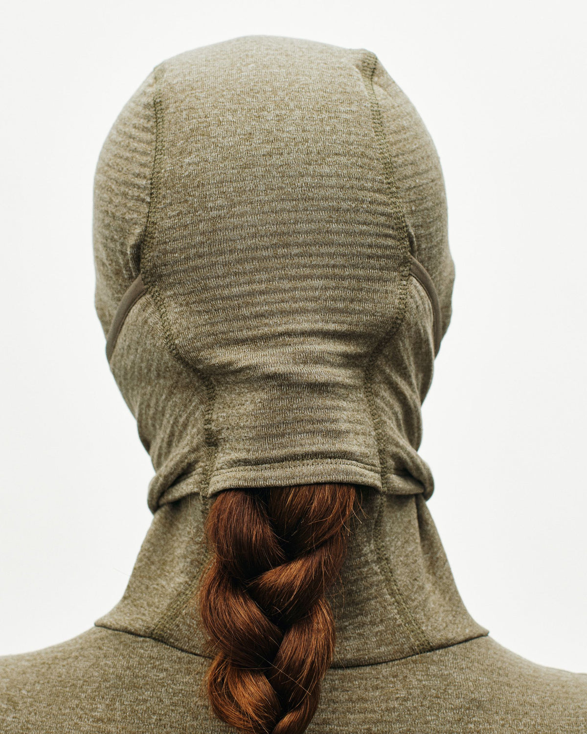 Grey Thermal Hooded Windproof base layer, rear view with hood up and braided hair visible #Color_Dark Stone