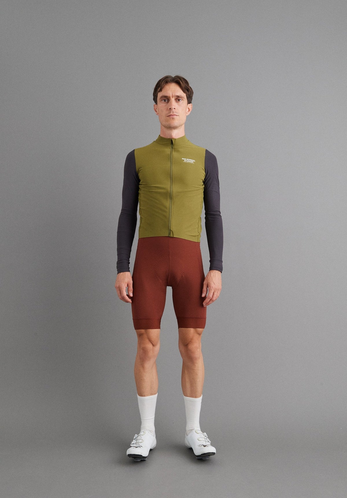 Maillot Largo Pas Normal Studios Mechanism en Deep Grey / Green, sobre ciclista #Color_Deep Grey / Green