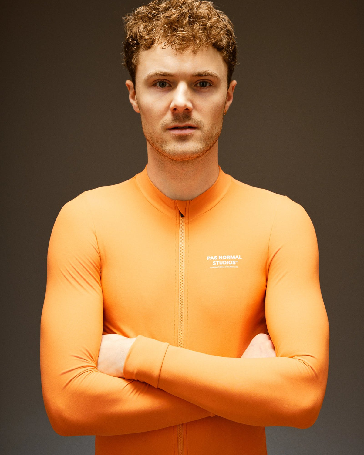 Maillot Largo Pas Normal Studios Mechanism en Dusty Orange, sobre ciclista #Color_Dusty Orange