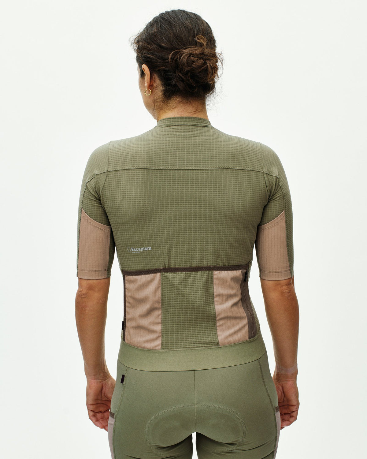 Maillot corto de mujer Pas Normal Studios Escapism en Light Olive, de espaldas sobre la ciclista #Color_Light Olive