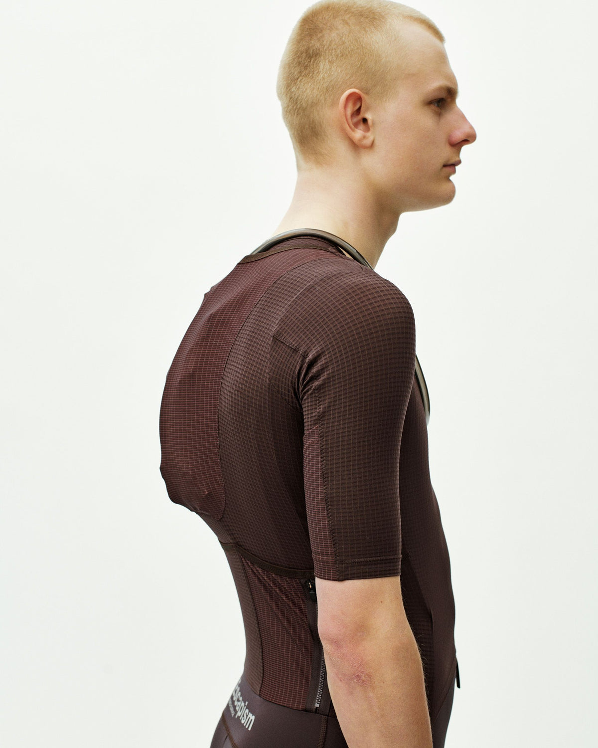 Dark Red Escapism speedsuit on model, side view with textured fabric and contrast trim #Color_Dark Red