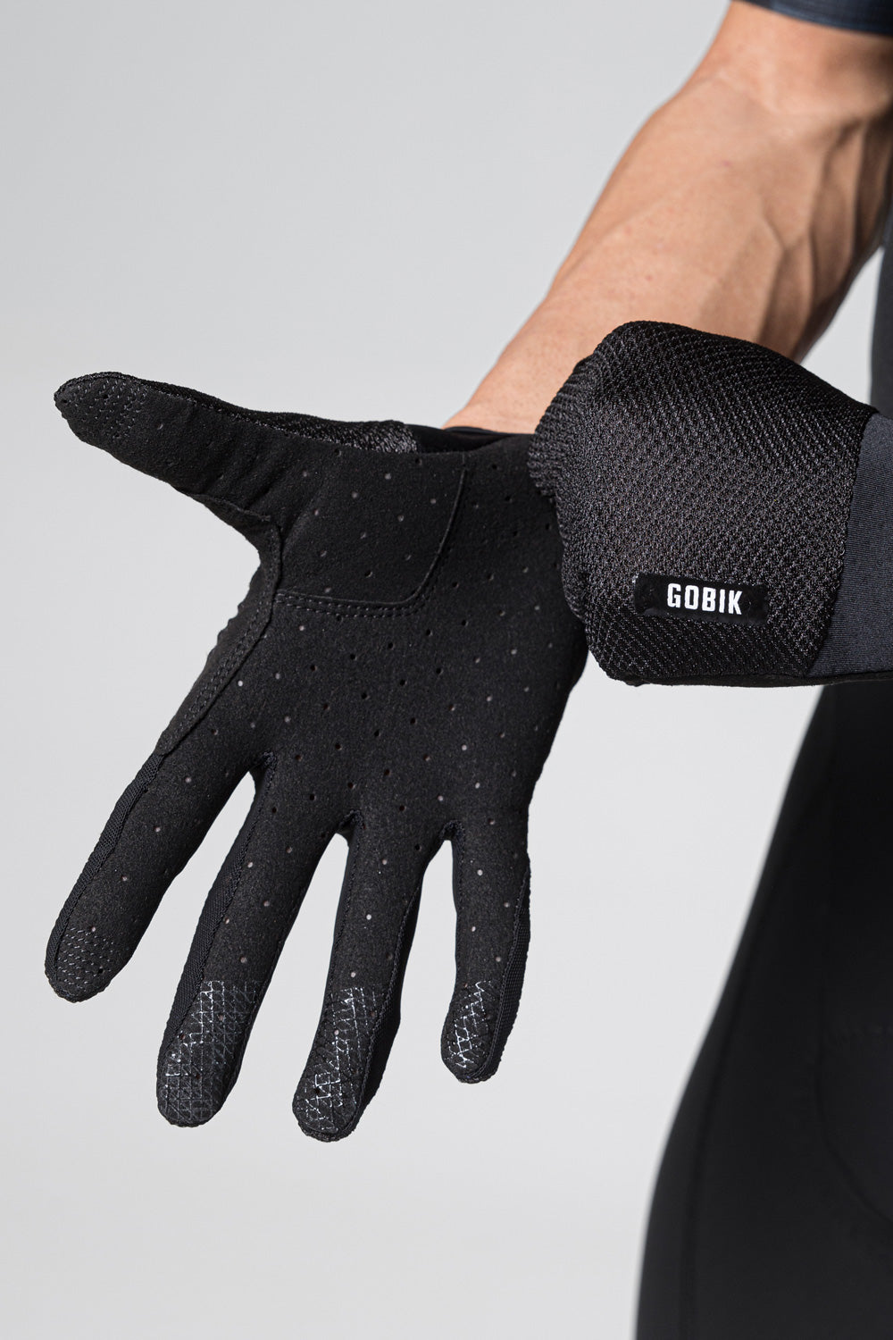 Guantes Gobik Lynx 2.0 en True Black, detalle de la palma del guante con el grip perforado sobre modelo #Color_True Black