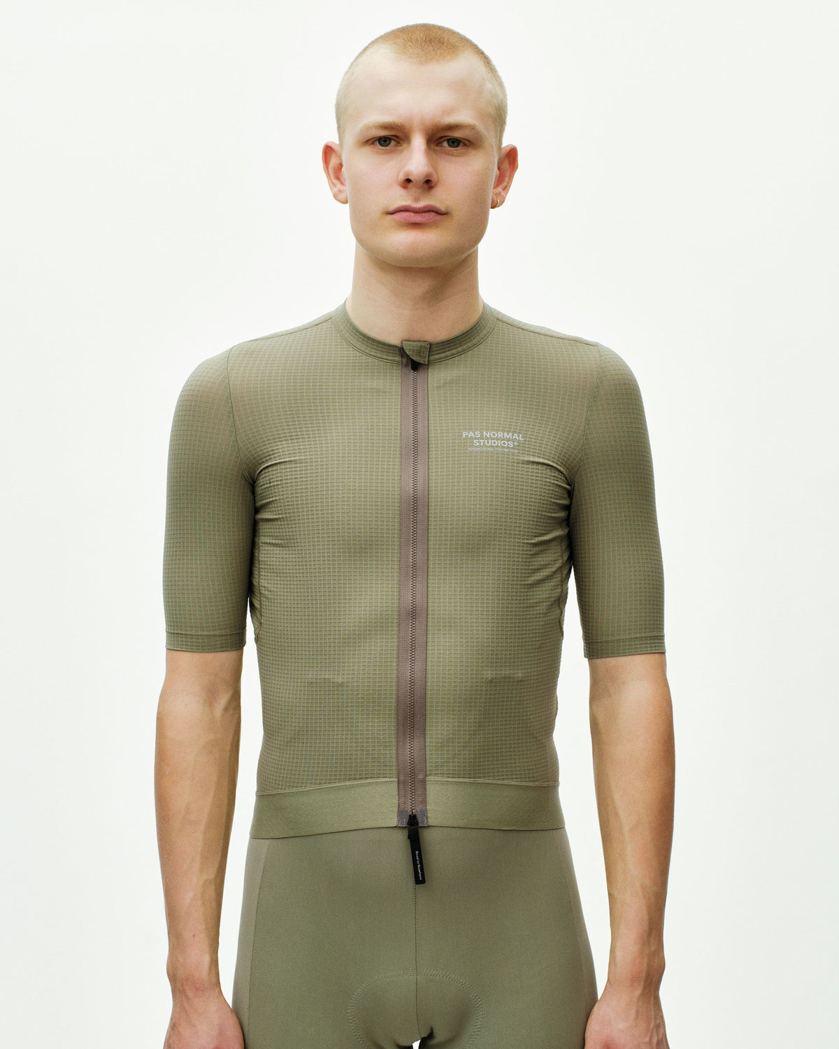 Maillot Corto Pas Normal Studios Escapism en Light Olive, vista frontal sobre ciclista #Color_Light Olive