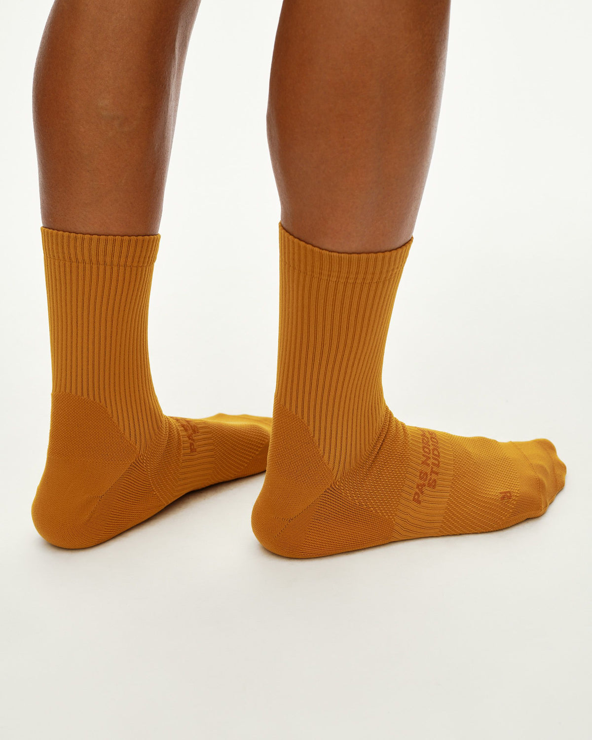 Calcetines Pas Normal Studios Balance Quarter en Ochre, puesta, vista trasera #Color_Ochre