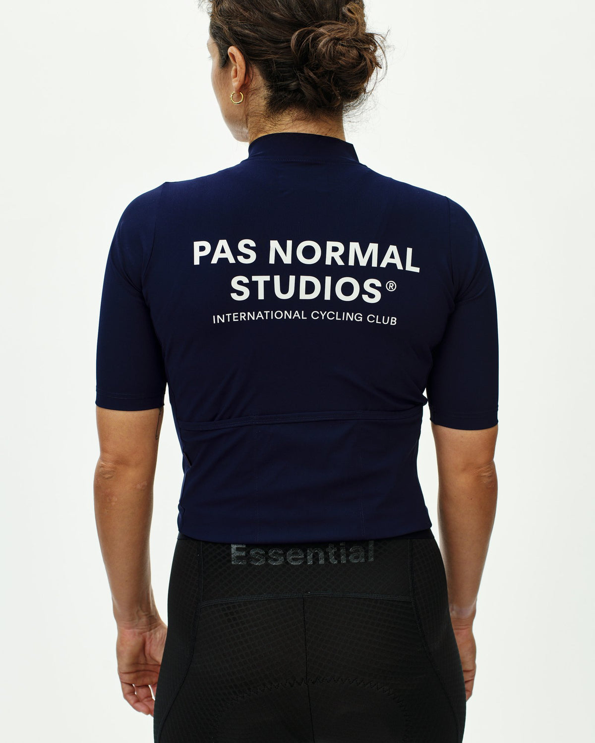 Maillot corto de mujer Pas Normal Studios Essential en Navy, vista trasera sobre la ciclista #Color_Navy