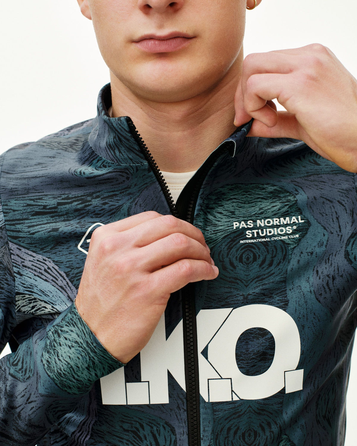 Dark Multi T.K.O. Mechanism Thermal cycling jacket, front detail on model with all-over print and large chest logo #Color_T.K.O. Dark Multi