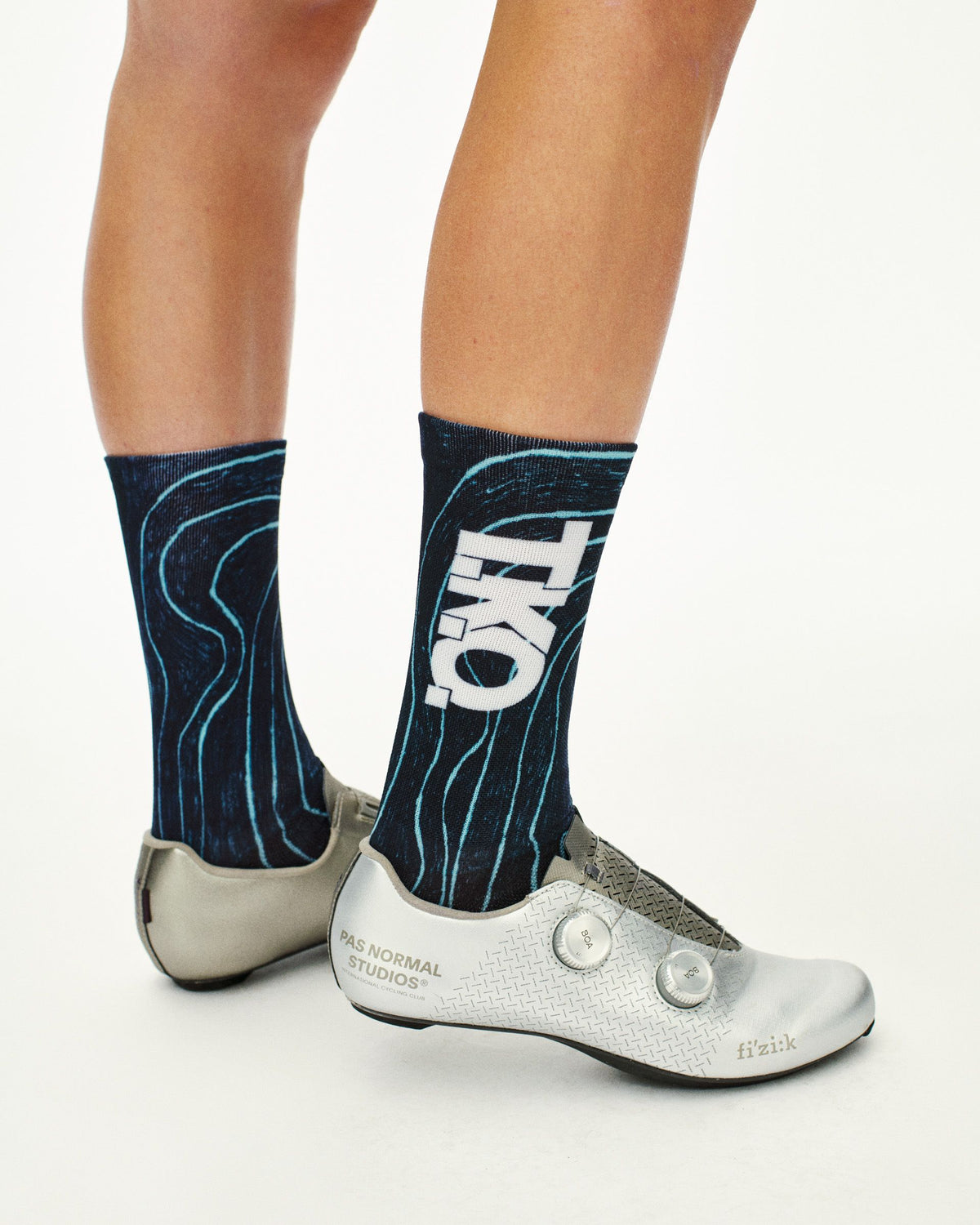 Blue T.K.O. Mechanism cycling socks on model, side view with white T.K.O. logo and teal topographic line print #Color_Blue