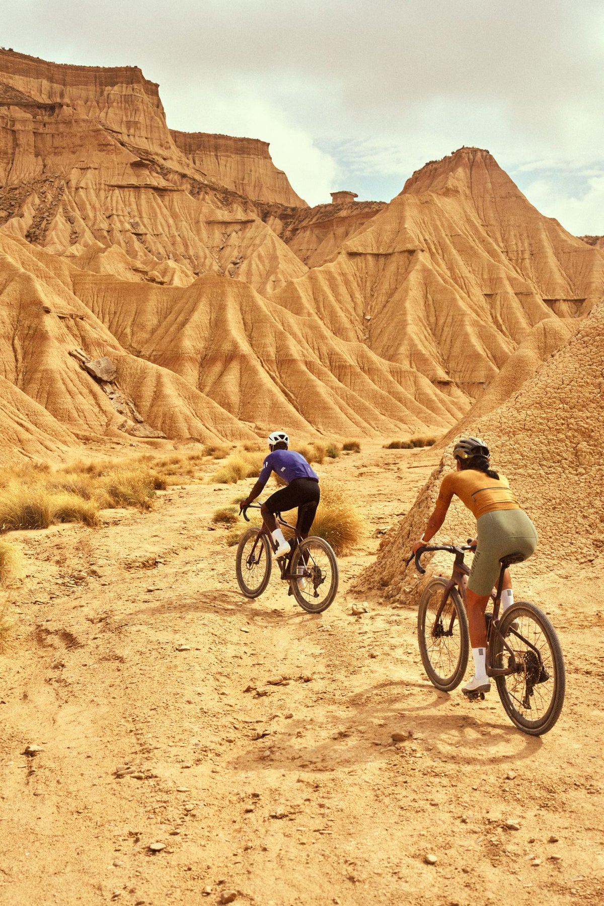 Dos ciclistas de gravel por un paisaje desértico con el COROS DURA 2 Solar