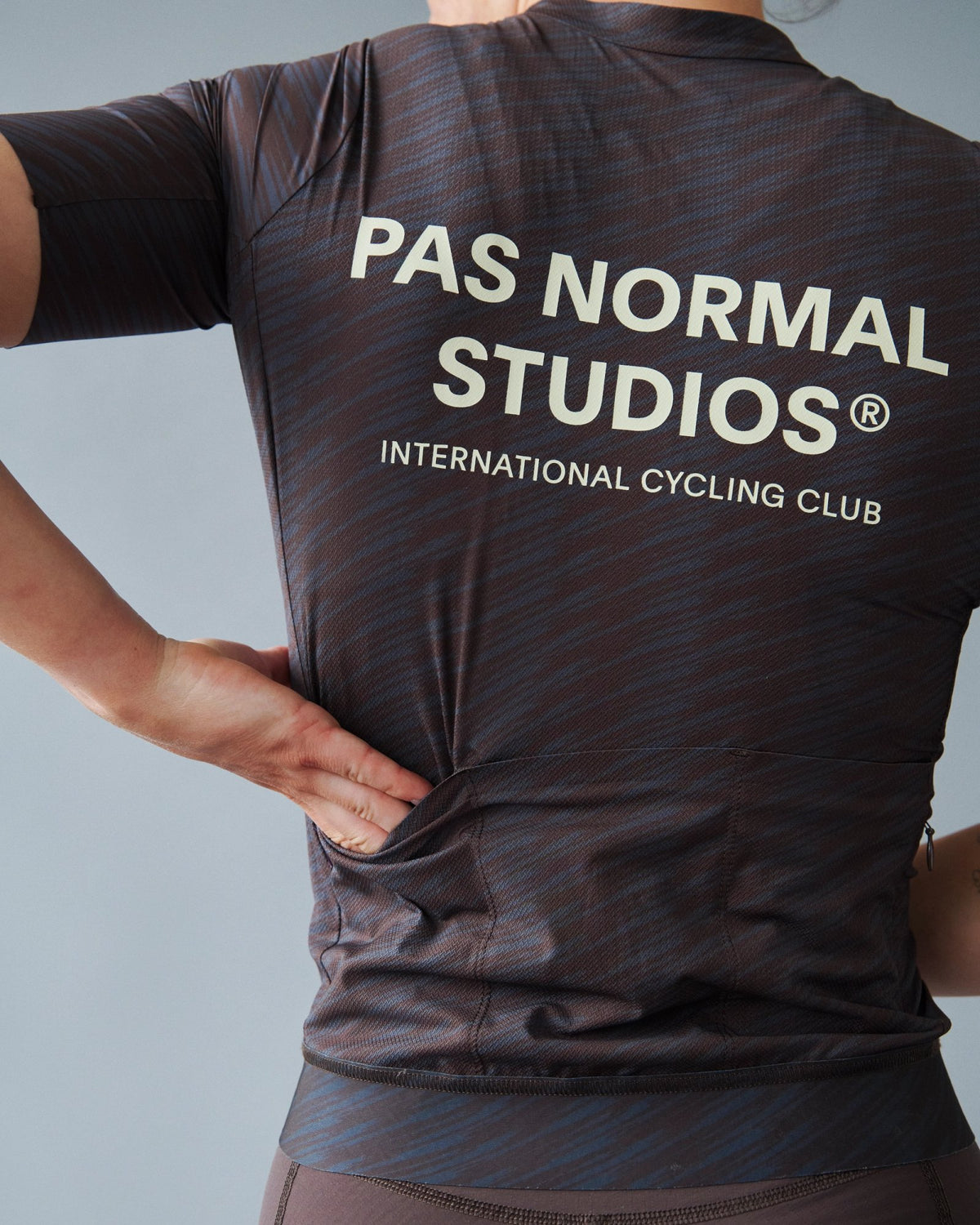 Maillot Mujer Pas Normal Studios Solitude en Dark Navy / Light Brown, sobre ciclista, vista trasera #Color_Dark Navy / Light Brown