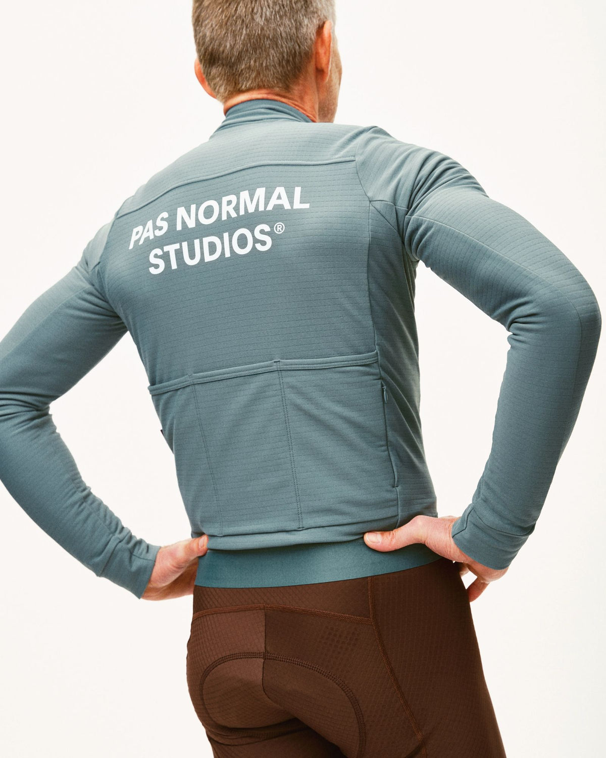 Maillot Largo Pas Normal Studios Essential en Grey Teal, vista trasera sobre ciclista #Color_Grey Teal