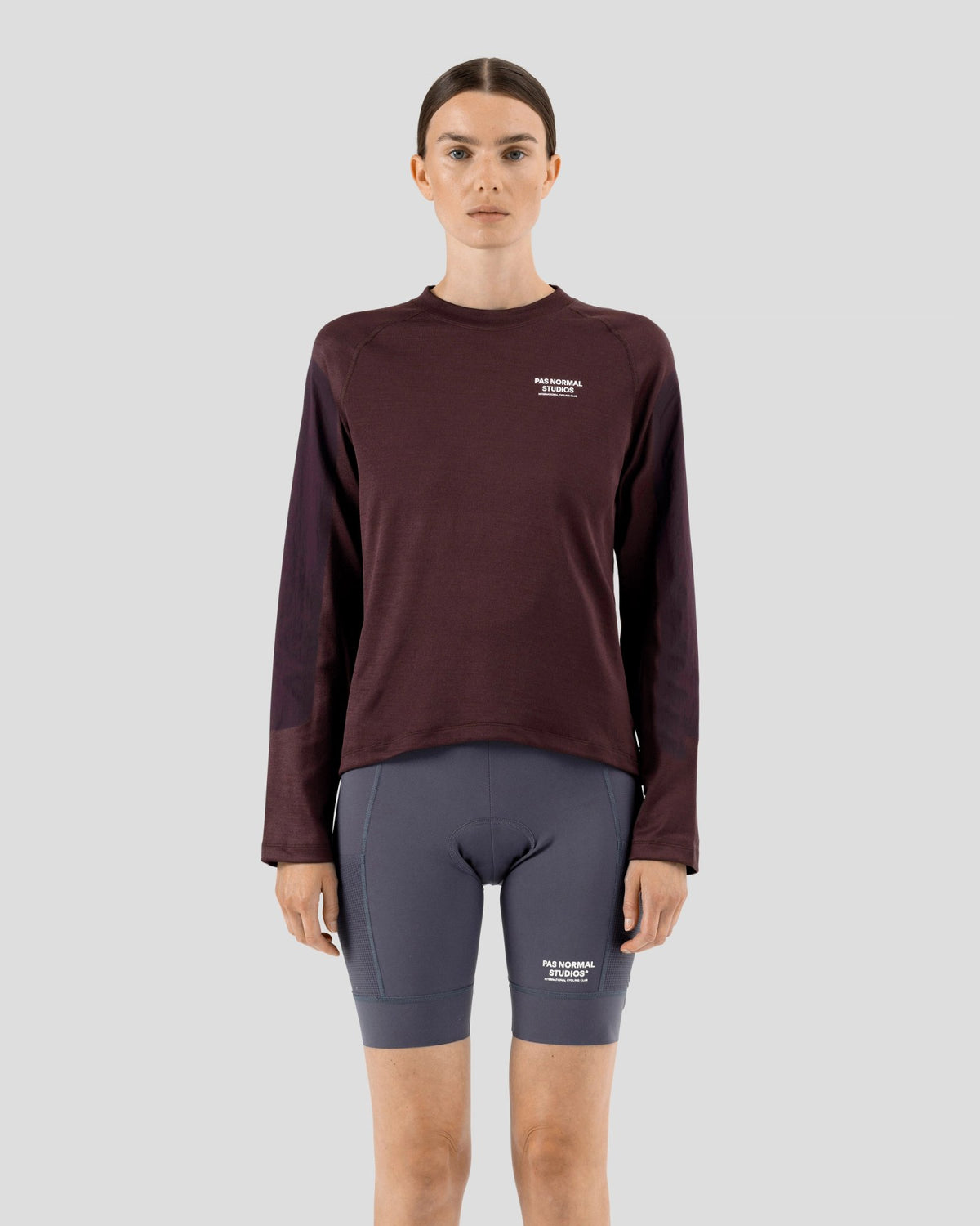 Camiseta técnica larga de mujer Pas Normal Studios Escapism en Dark Red, sobre la ciclista #Color_Dark Red