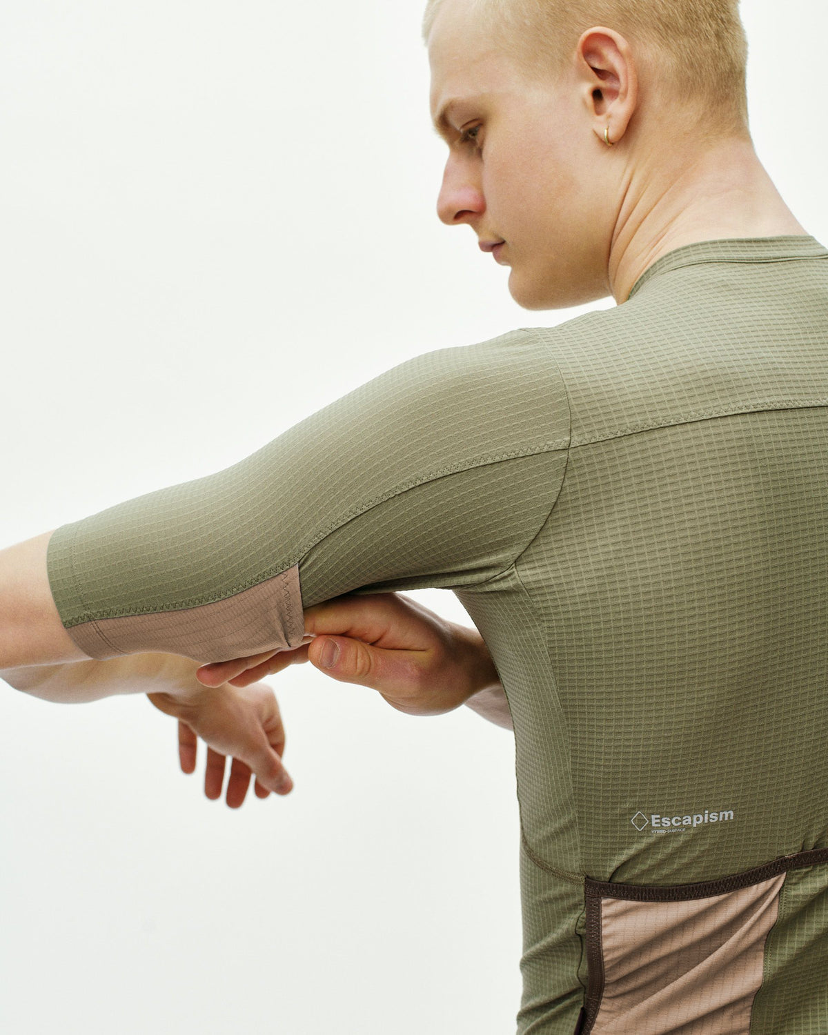Maillot Corto Pas Normal Studios Escapism en Light Olive, vista lateral sobre ciclista #Color_Light Olive
