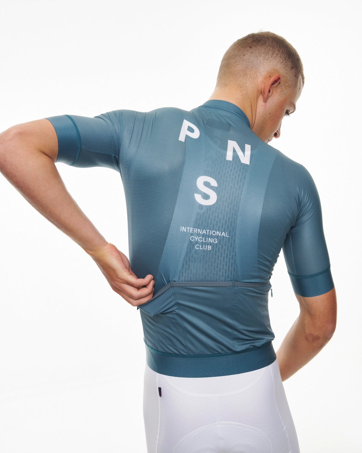 Maillot Corto Pas Normal Studios Mechanism en Dusty Teal, vista trasera sobre ciclista #Color_Dusty Teal