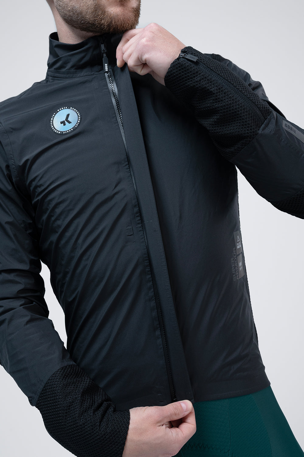 Chaqueta Gobik Superarmour en Royal Black, detalle del torso subiendo la cremallera frontal #Color_Royal Black