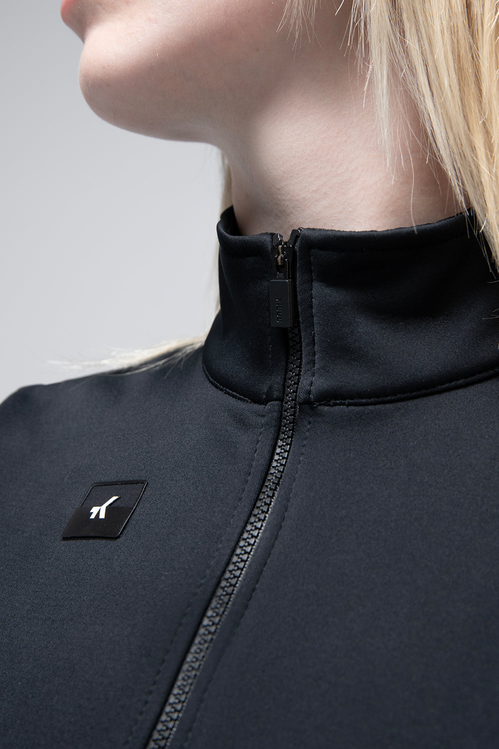 Chaleco Gobik Pathfinder en Ink Black, detalle del cuello alto y la cremallera #Color_Ink Black