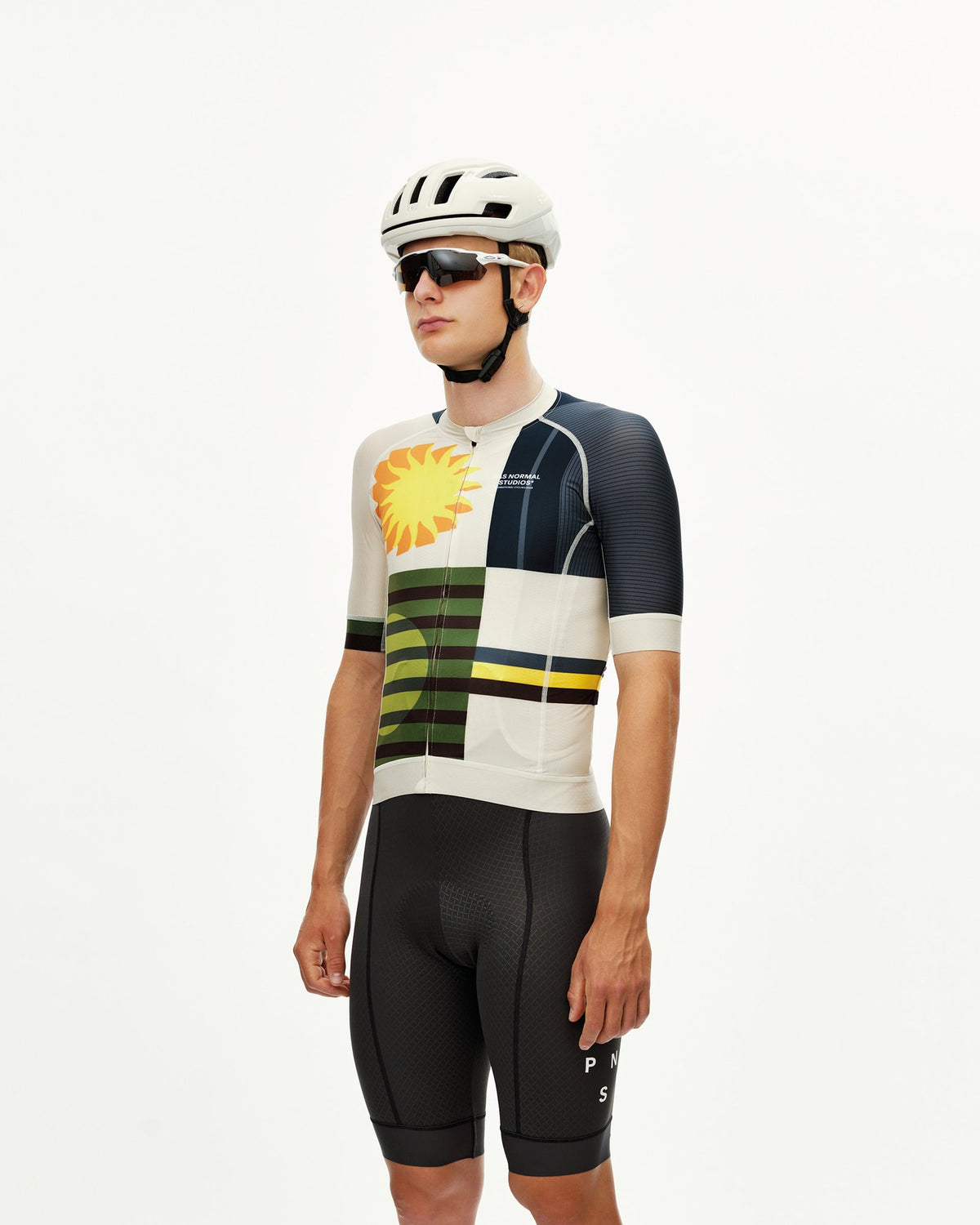Maillot Corto Pas Normal Studios Mechanism en AOP International Sand, vista frontal sobre ciclista #Color_AOP International Sand