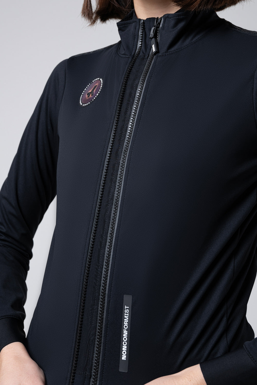 Chaqueta Gobik Armour 2.0 en Vanta, detalle del torso con la cremallera frontal y el emblema #Color_Vanta