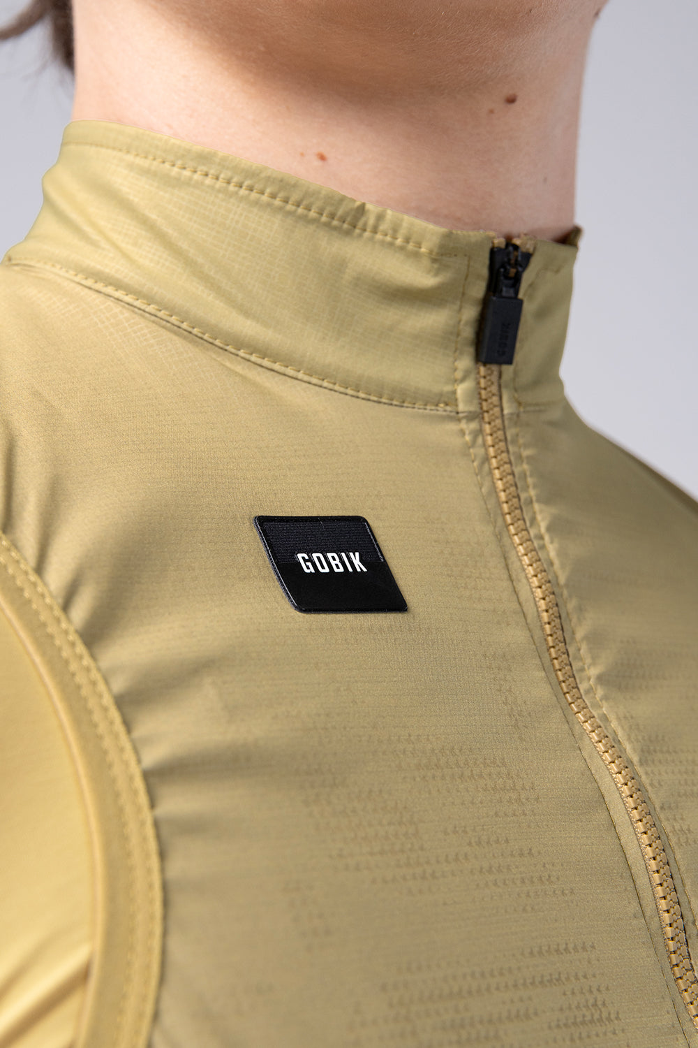 Chaleco Mujer Gobik Plus 2.0 en Keemun, detalle del cuello y el logotipo #Color_Keemun