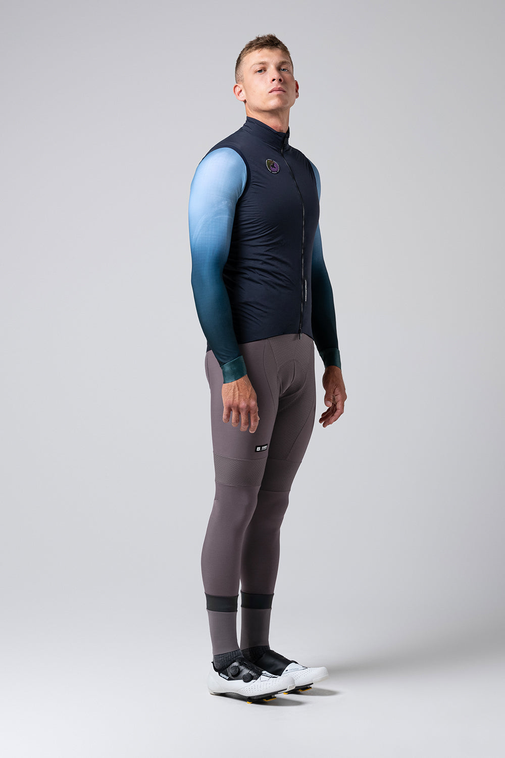 Chaleco Gobik Eminent 2.0 en Ultrablue, vista lateral de cuerpo entero sobre modelo masculino #Color_Ultrablue