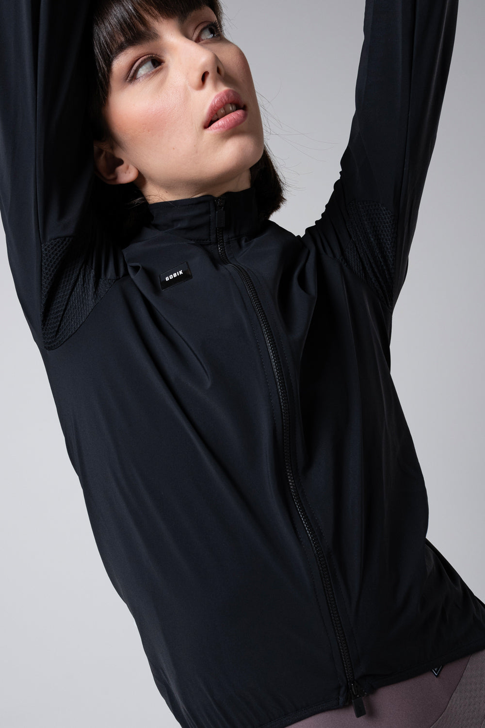 Chaqueta Gobik Selkie en Ink Black, vista frontal de medio cuerpo con el brazo levantado #Color_Ink Black