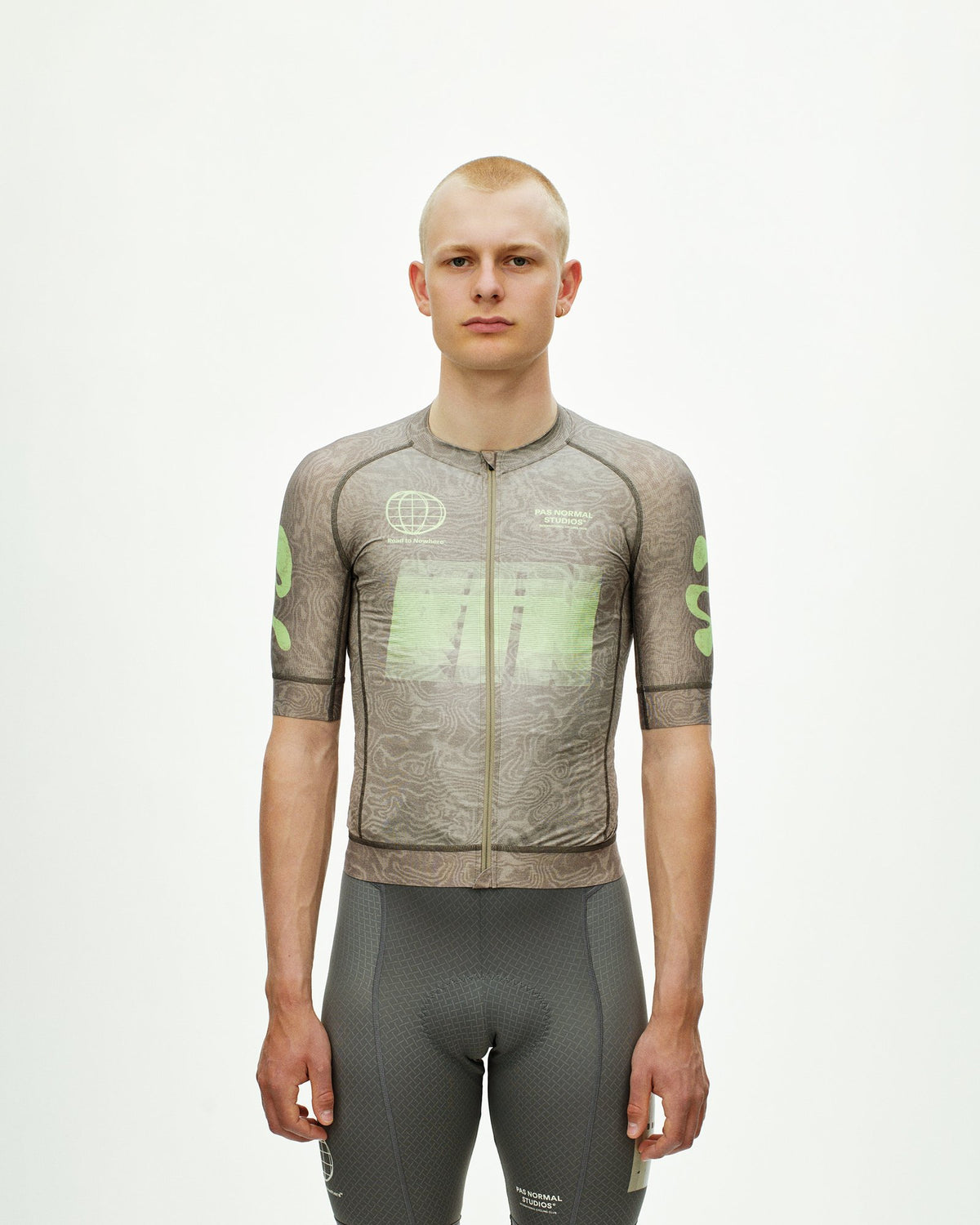 Maillot Corto Pas Normal Studios Mechanism Logo en AOP RTN Earth, vista frontal sobre ciclista #Color_AOP RTN Earth