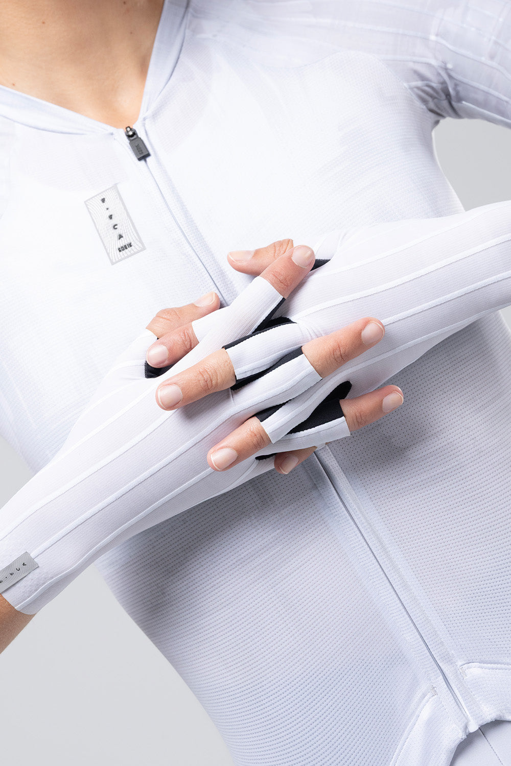 Guantes Gobik Kinetic en White, guantes puestos sobre modelo con maillot blanco, manos juntas #Color_White