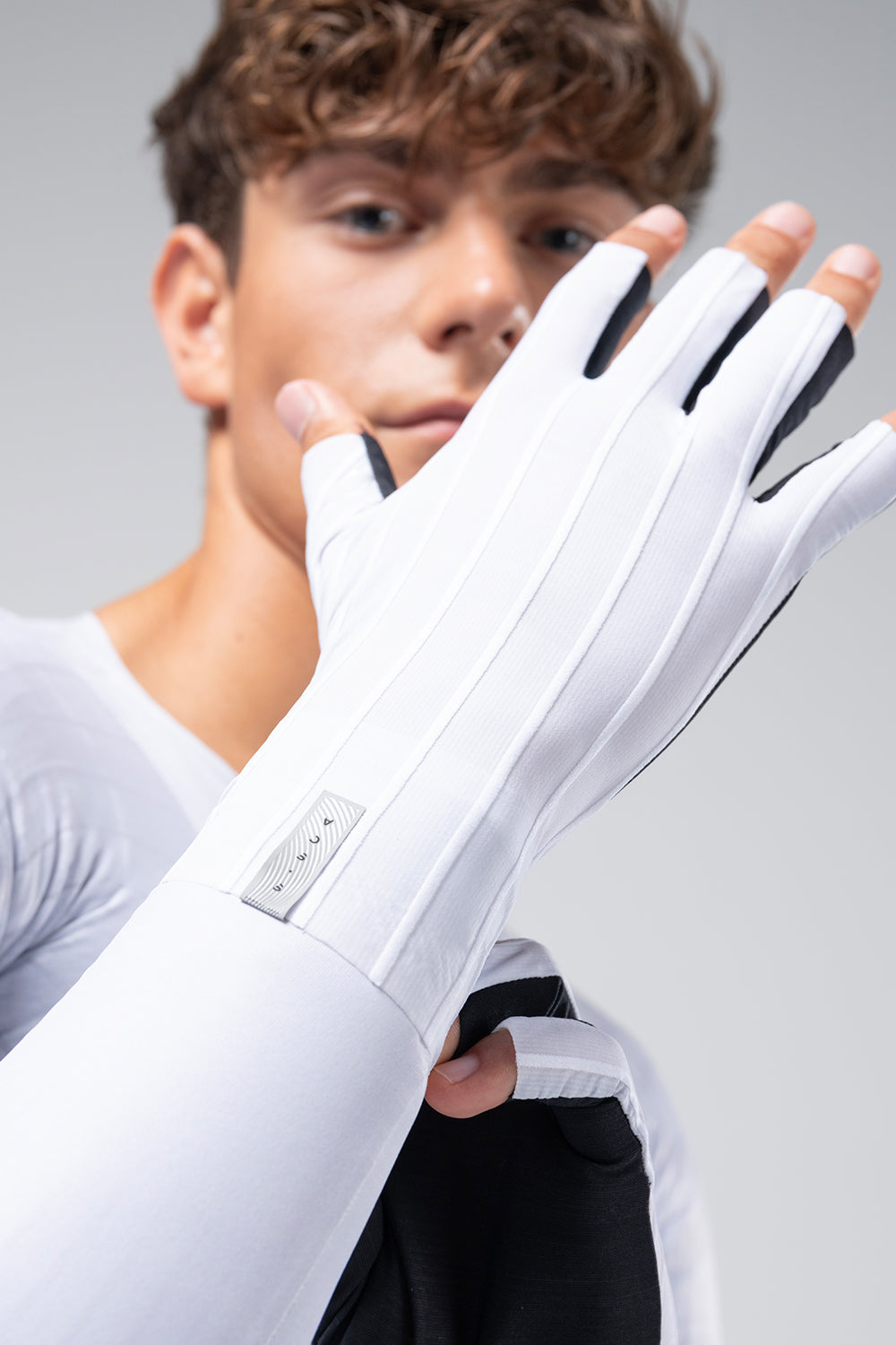 Guantes Gobik Kinetic en White, retrato de ciclista ajustándose los guantes #Color_White