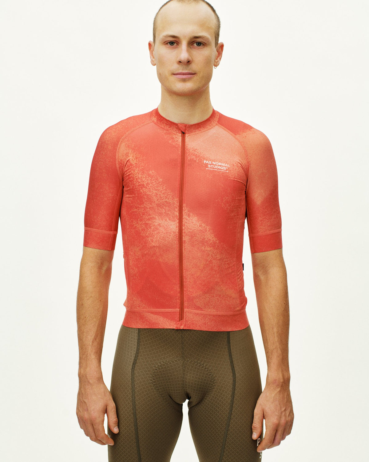 Maillot Corto Pas Normal Studios Mechanism en AOP Hibiscus Orange, detalle sobre ciclista #Color_AOP Hibiscus Orange