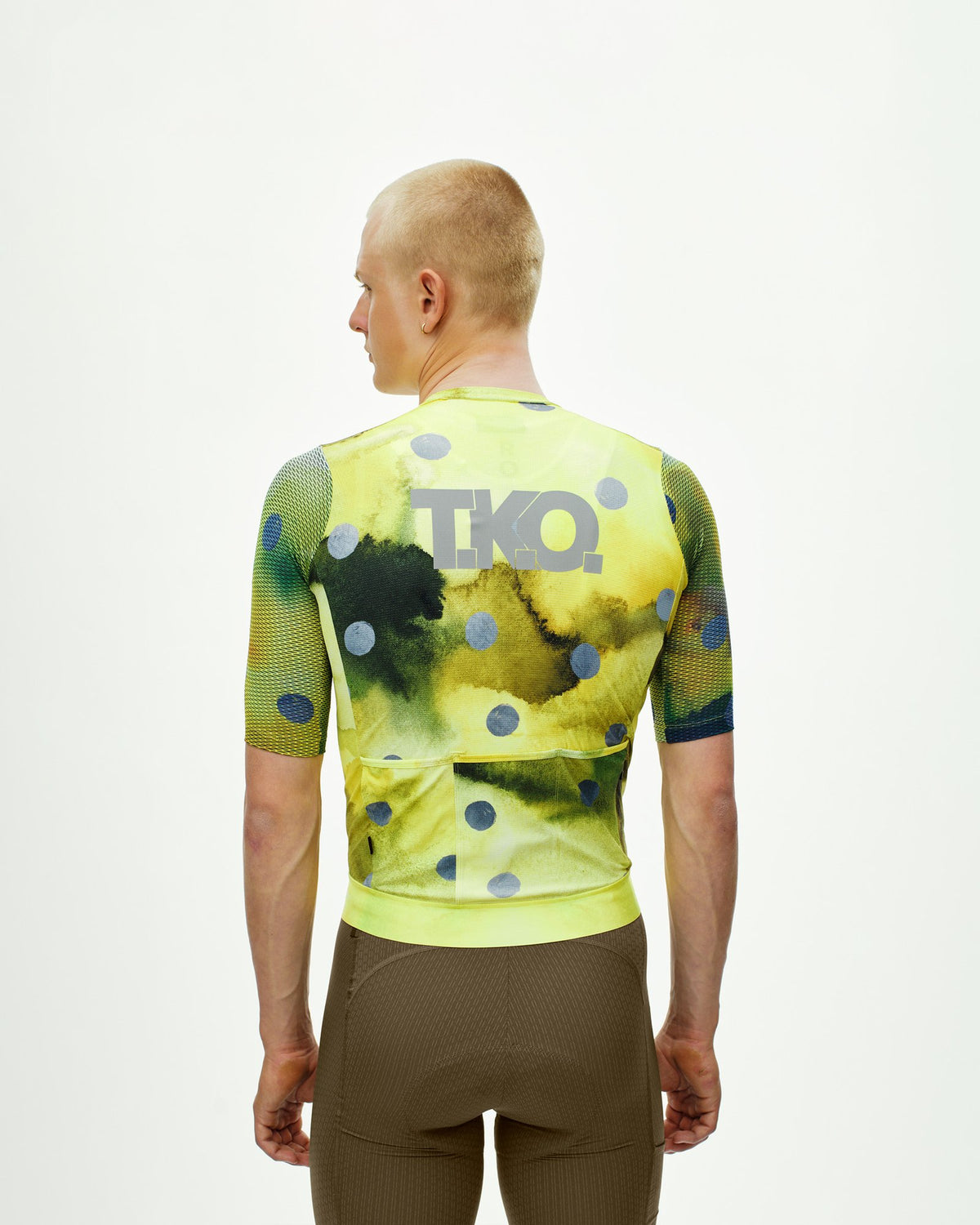 Maillot corto Pas Normal Studios T.K.O. Essential Light en T.K.O. Yellow, de espaldas sobre el ciclista #Color_T.K.O. Yellow