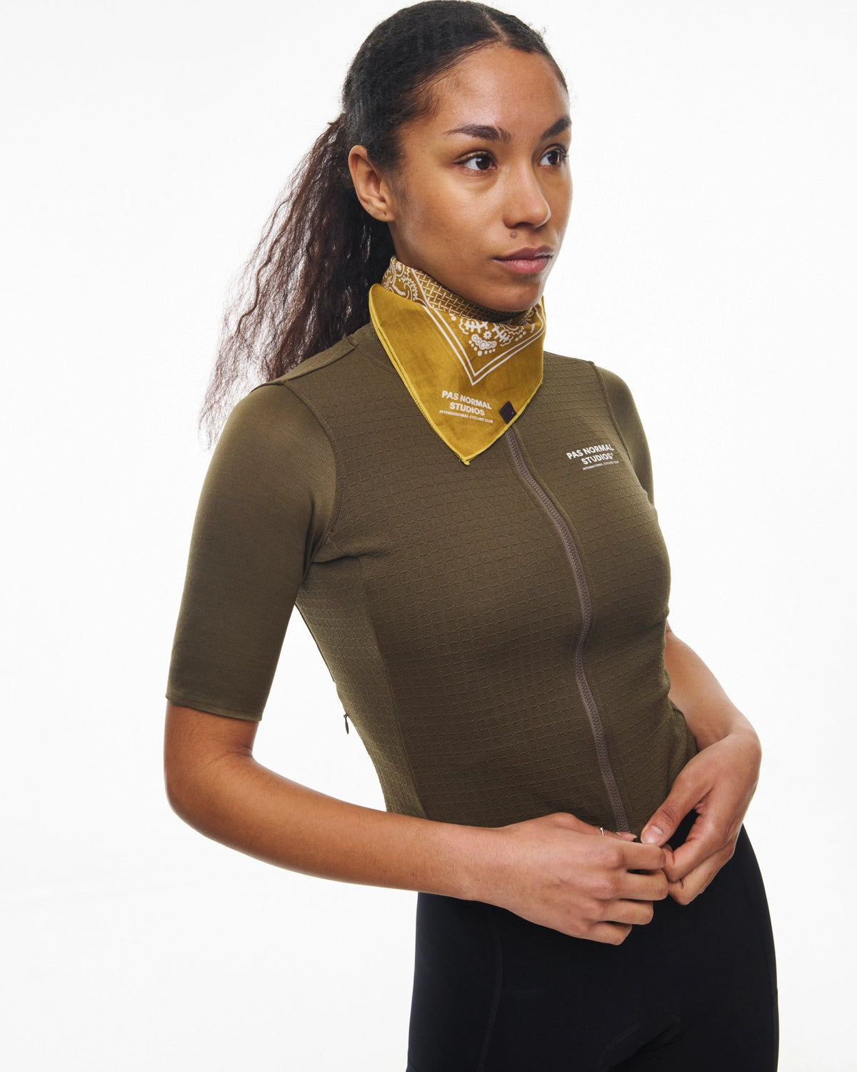 Maillot corto de mujer Pas Normal Studios Escapism Wool en Dark Stone, sobre la ciclista #Color_Dark Stone