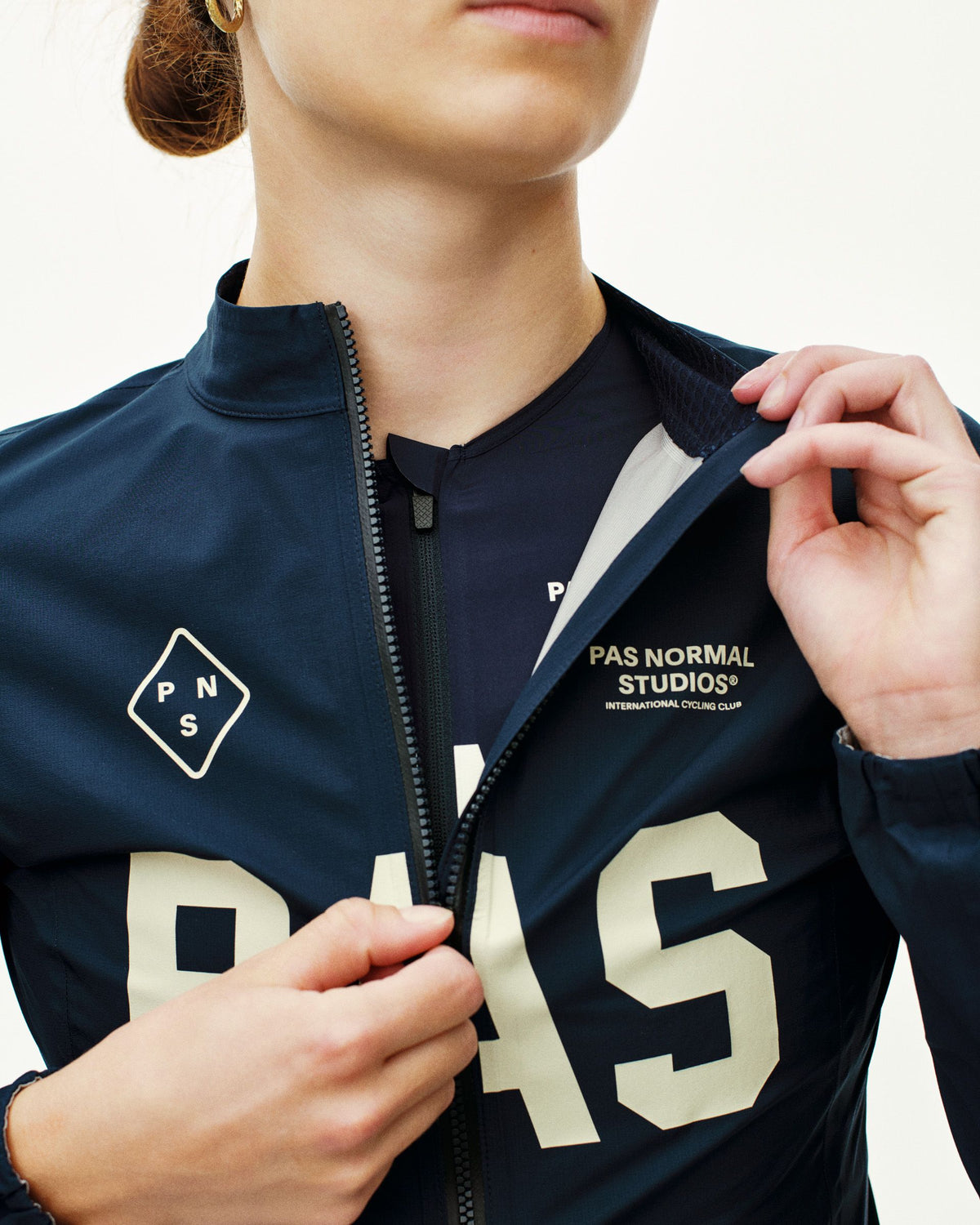 Navy PAS Mechanism Rain cycling jacket on model with white PAS lettering and contrast zip #Color_Navy