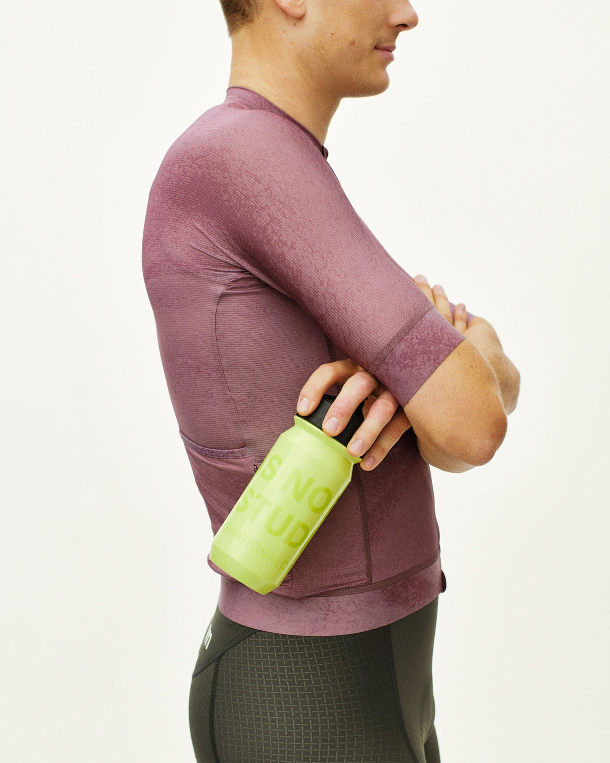 Green Essential Logo water bottle held by model in purple long sleeve top #Color_Wasabi Green