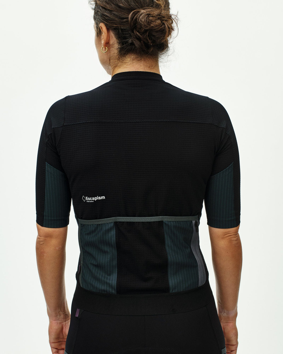 Maillot corto de mujer Pas Normal Studios Escapism en Black, de espaldas sobre la ciclista #Color_Black