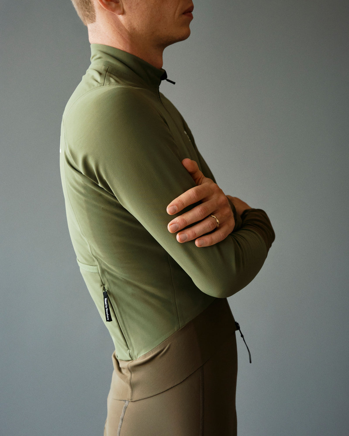 Army Green Mechanism Thermal jacket on model, side view with high collar and zip pocket #Color_Army Green / Dark Stone