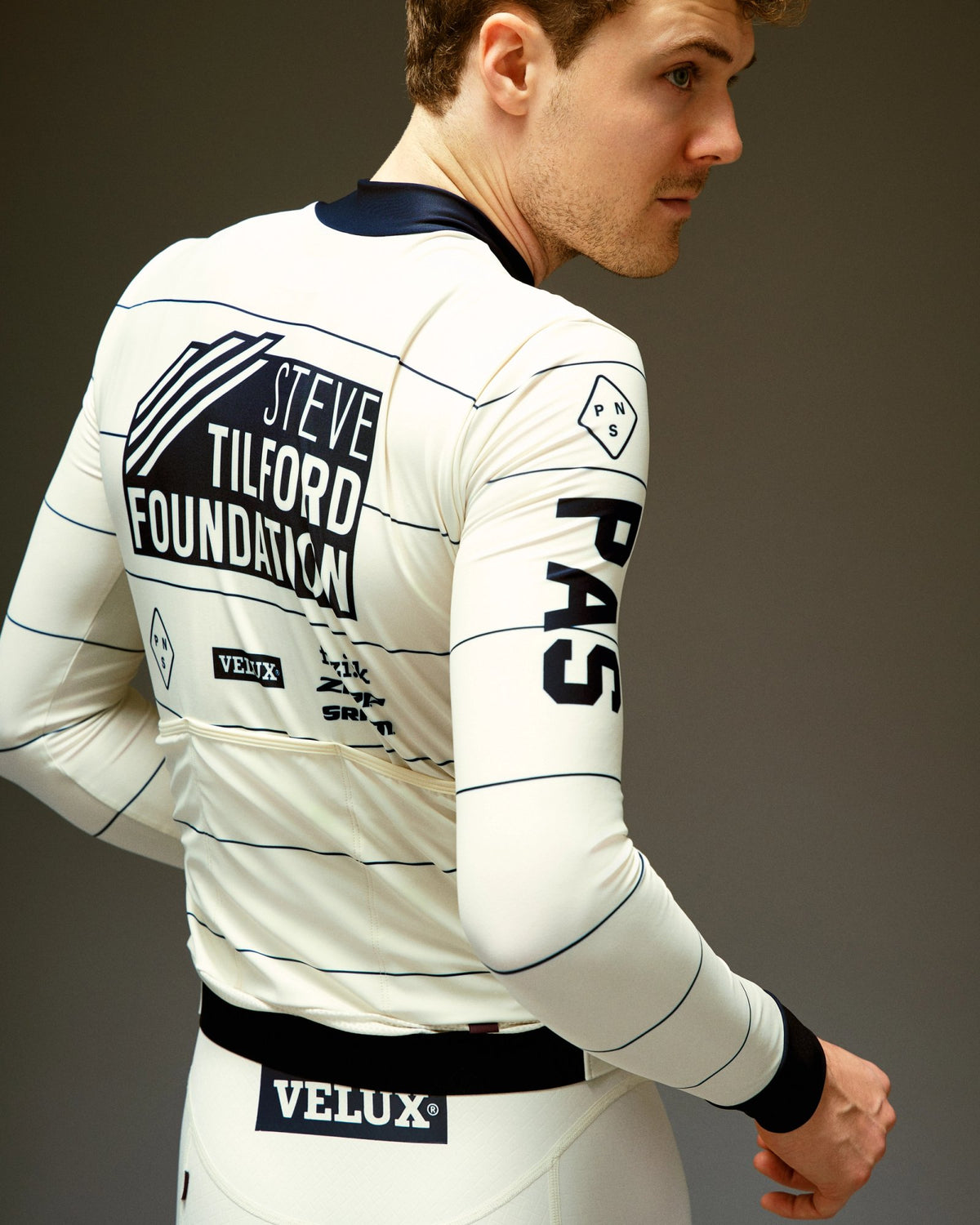 Maillot largo Pas Normal Studios STFR Mechanism en Off White, de espaldas sobre el ciclista #Color_Off White