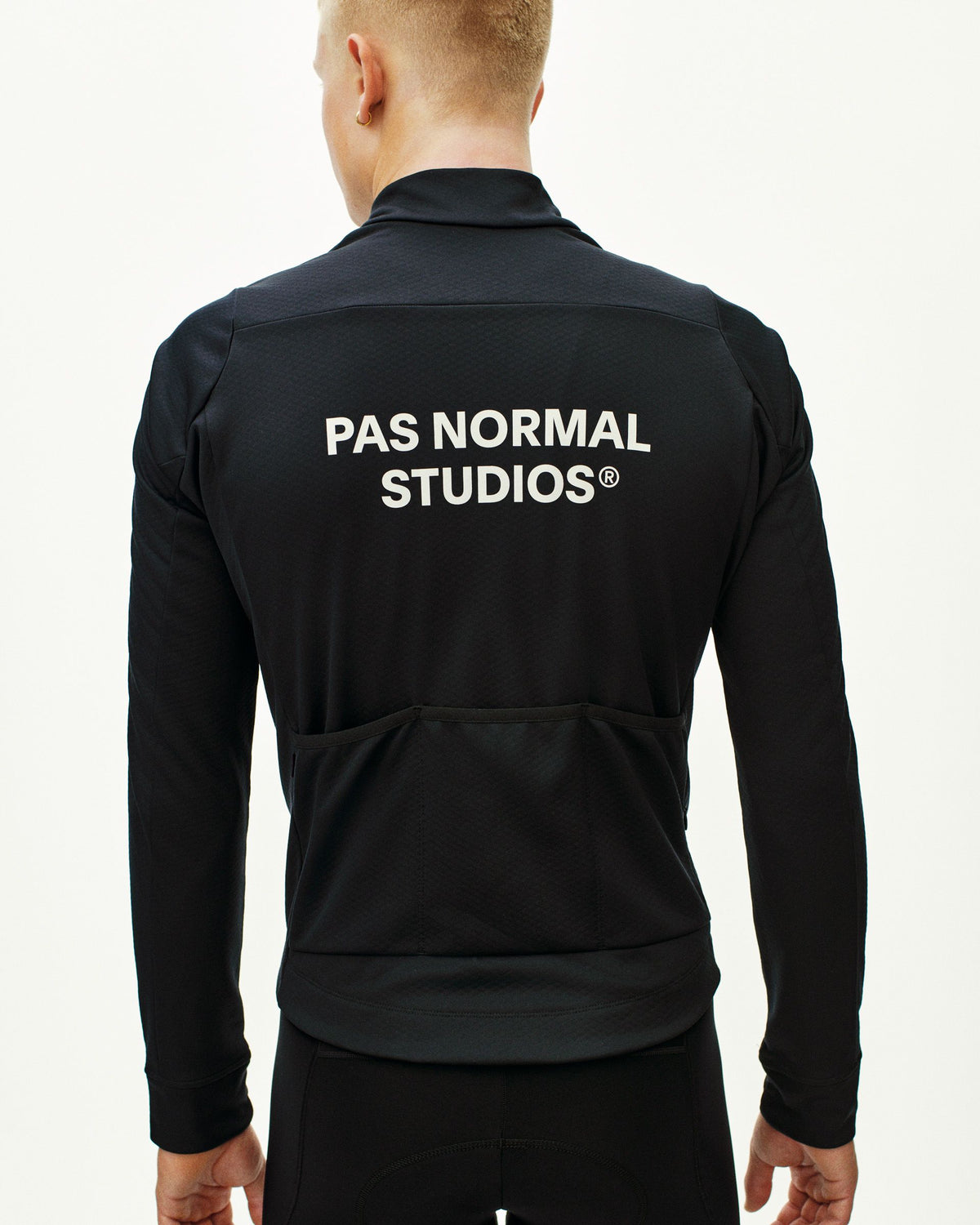 Maillot Largo Pas Normal Studios Essential Thermal en Black, vista trasera sobre ciclista #Color_Black