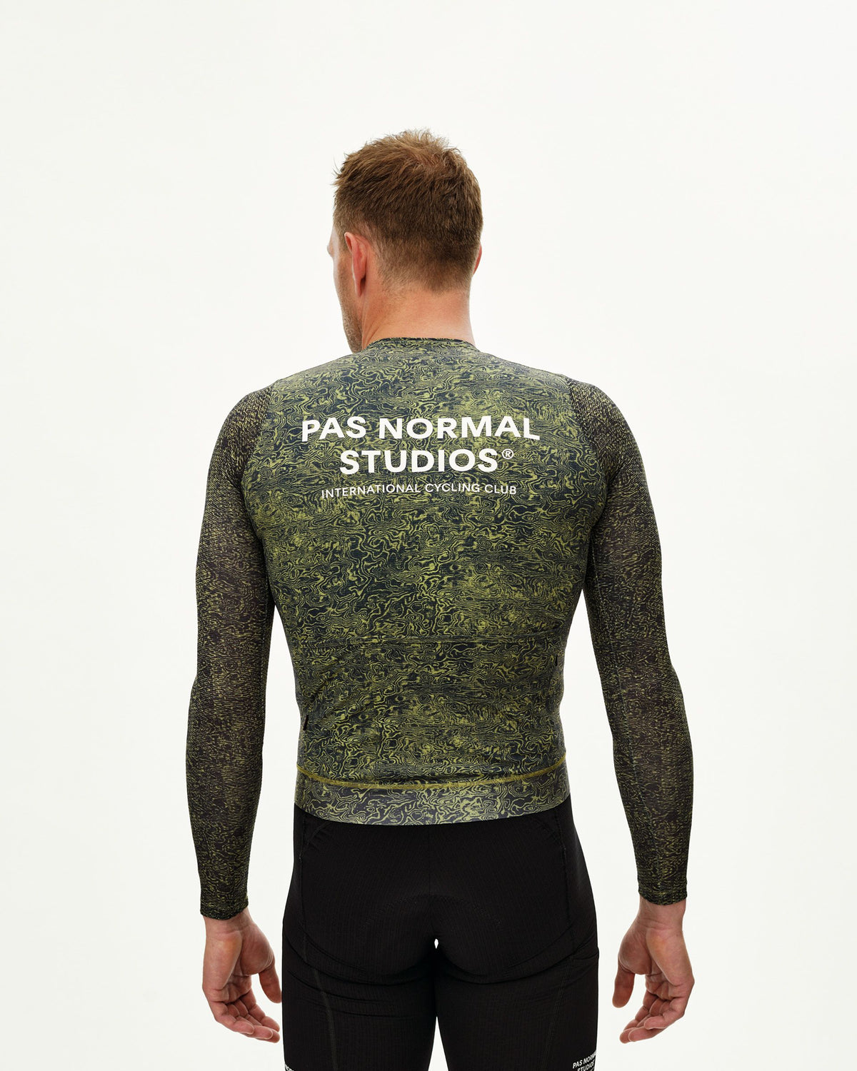 Maillot Largo Pas Normal Studios Essential Light en AOP Grain Dark Lime, vista trasera sobre ciclista #Color_AOP Grain Dark Lime