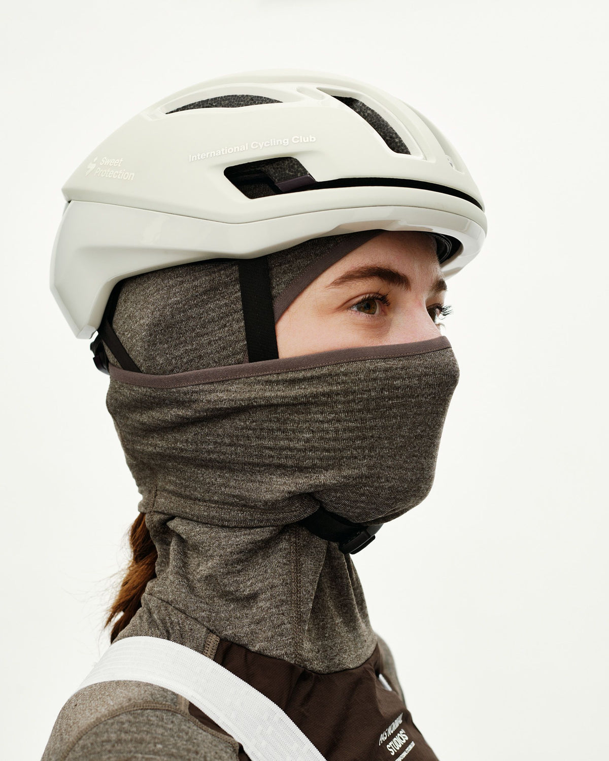 Dark Coffee brown Essential thermal hooded cycling base layer on model, side view worn as neck gaiter covering face #Color_Dark Coffee