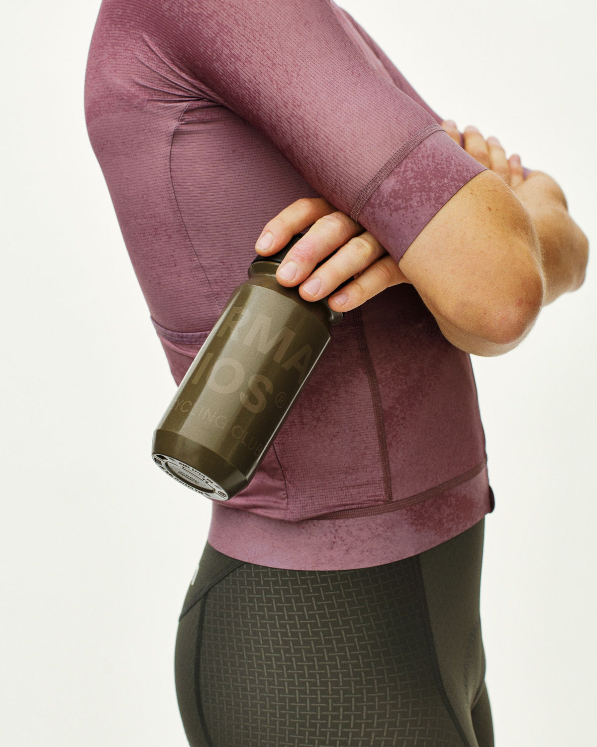 Brown Essential Logo water bottle on model with green tinted glass design #Color_Mud